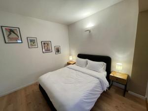 a bedroom with a bed with white sheets and two lamps at Amiata Loft Design - Monte Amiata - Free Parking in Seggiano