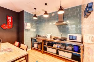 uma cozinha com um balcão com um micro-ondas e uma mesa em Factory Hostels Barcelona em Barcelona