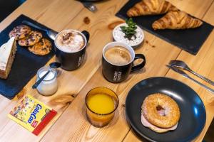 a table with two cups of coffee and a plate of doughnuts at Factory Hostels Barcelona in Barcelona