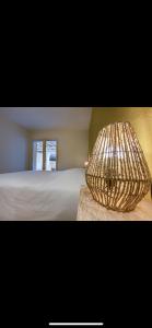 a picture of a bedroom with a bed and a lamp at « Le Clos de la Côte d’Or » in Ladoix Serrigny