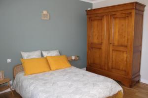 une chambre avec un lit et une armoire en bois dans l'établissement La Villa Corentine, à Grand-Corent