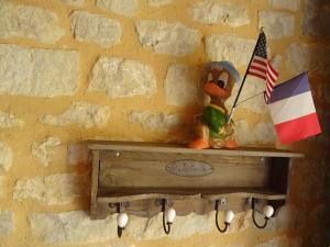 a rubber duck holding a flag on a wall at La ferme aux chats in Formigny