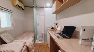 a small bedroom with a desk with a laptop on it at Haechi Stay GuestHouse - For foreigners only in Seoul