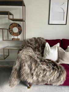a faux fur blanket on a couch in a living room at The wing at Old Hundred in Tormarton