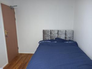 a bedroom with a bed with a blue comforter at Double En-suite Rooms in Nevendon