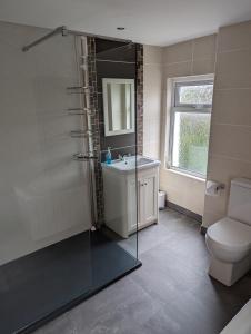 a bathroom with a shower and a sink and a toilet at Prospect House - Elegant 4-Bed Family Escape Near Ward Park & Marina in Bangor +15 photos