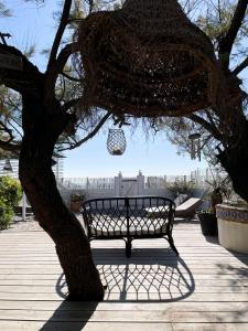 um banco sentado ao lado de uma árvore com um ornamento pendurado em Mas Andalou Fabuleuse première ligne de mer, plage privative em Frontignan