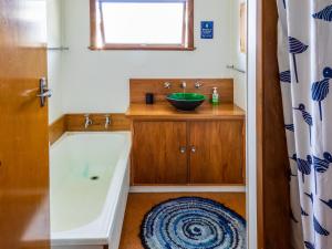 ein Badezimmer mit Waschbecken und Badewanne in der Unterkunft Godwit Cottage - Pākawau Beachfront Holiday Home in Pakawau + 18 Fotos