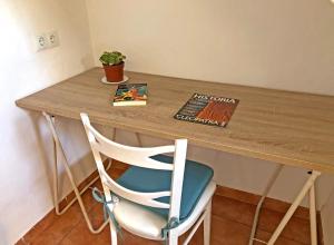 a wooden table with a chair and a book at ALOJAMIENTO NO ACTIVo in Moclín +6 photos