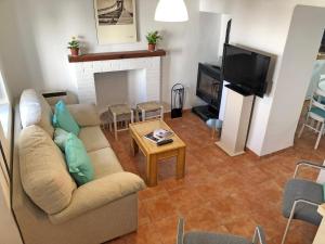 a living room with a couch and a tv at ALOJAMIENTO NO ACTIVo in Moclín