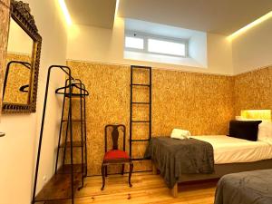 a bedroom with a bed and a ladder and a chair at A casa na Estrela in Lisbon