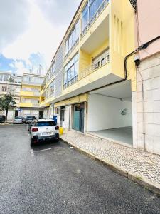 un coche aparcado en un aparcamiento al lado de un edificio en A casa na Estrela en Lisboa