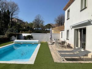 una piscina in un cortile accanto a una casa di Villa 8 personnes piscine terrain de boules a Roquebrune-sur Argens