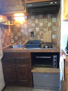 a small kitchen with a sink and a stove at Princesse jonquille in Demi-Quartier