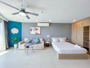a bedroom with a bed and a couch and a ceiling fan at Sophia Homestay - The Sóng Vũng Tàu in Vung Tau