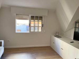 a white living room with a window and a couch at Magnifico Piso Nuevo con Vistas in Vigo