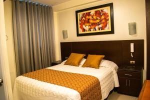 Hotel Hatunkay Chaclacayo في ليما: غرفة نوم بسرير ودهان على الحائط