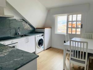 a kitchen with a sink and a washing machine at Magnifico Piso Nuevo con Vistas in Vigo