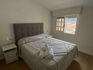 a bedroom with a bed with towels on it at Magnifico Piso Nuevo con Vistas in Vigo