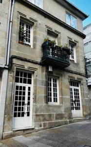 a stone building with a balcony and windows at Magnifico Piso Nuevo con Vistas in Vigo