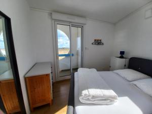 ein Schlafzimmer mit einem Bett und einem großen Fenster in der Unterkunft Balcon sur mer in Saint-Gilles-Croix-de-Vie