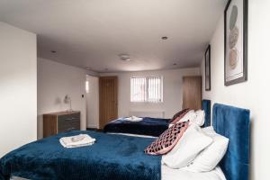 a bedroom with two beds and a blue blanket at Refined Comforts for Two Room 5 in Manchester