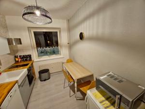 eine Küche mit einem Tisch, einem kleinen Tisch und einem Fenster in der Unterkunft Flora furnished fair apartments in Essen