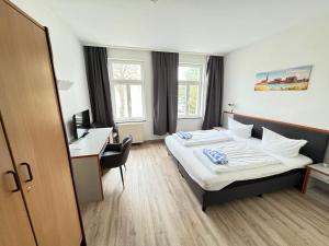 ロストックにあるAppartement-Hotel Rostockのベッドとデスクが備わるホテルルームです。