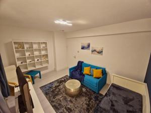 a living room with a blue couch and a table at Flora furnished fair apartments in Essen