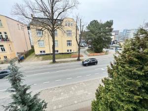 une voiture circulant sur une route devant un bâtiment dans l'établissement Appartement-Hotel Rostock, à Rostock