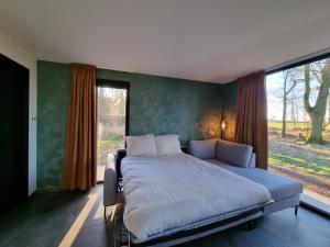 een bed in een slaapkamer met een groot raam bij CortenHuys in Enschede