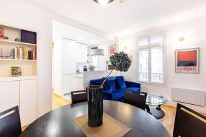 a living room with a table and a blue couch at GuestReady - Parisian Gem by la Bastille in Paris