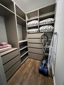 a walk in closet with a vacuum cleaner in it at Saulės Tako apartamentai in Druskininkai