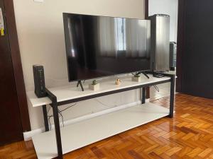 a flat screen tv sitting on top of a tv stand at Apartamento 2 QTS Excelente Localização - EV05 in Maringá