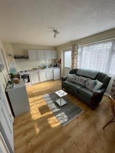 a living room with a couch and a table at Hillview 1st floor apartment in Brean