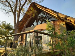 una casa con un árbol delante en Syeta Bush Lodge 3 Bed Bush Villa, en Nelspruit