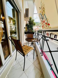 balcón con 2 sillas, mesa y esquís en Dreamy Luxury Studio, en Nafpaktos