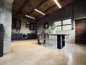 Una cocina con una mesa y sillas en una habitación. en Syeta Bush Lodge 3 Bed Bush Villa, en Nelspruit