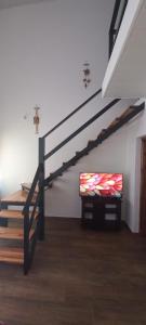 a living room with a tv and a staircase at Casa - Departamento - Loft in Concepción del Uruguay