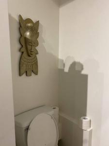 a bathroom with a toilet with a statue on the wall at Studio entièrement privé aux quatre vents in Lac-Mégantic