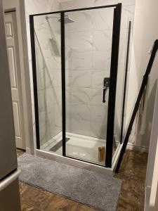 a shower with a glass door in a bathroom at Studio entièrement privé aux quatre vents in Lac-Mégantic