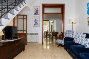 Una sala de estar con un sofá azul y un televisor en YourHouse Ca Mado Josefa house, en Santa Margalida