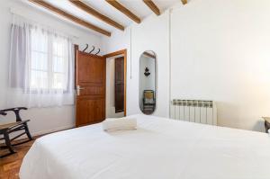 Un dormitorio blanco con una cama grande y una ventana. en YourHouse Ca Mado Josefa house, en Santa Margalida