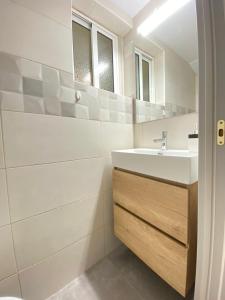 a white bathroom with a sink and a mirror at Apartamento Turístico en el centro in Tarragona