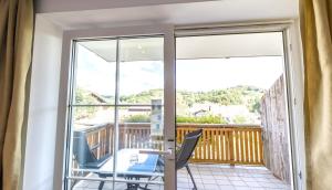 a balcony with two chairs and a sliding glass door at Das Reiners in Grafenau