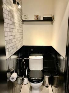 a bathroom with a toilet and a black tiled wall at Antwerp Central Park in Antwerp