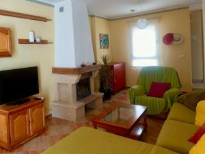 sala de estar con sofá y chimenea en Chalet adosado con azotea andaluza y patio, junto a la playa, en Isla Cristina