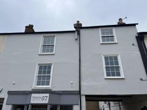 a white building with windows and a sign on it at Newly Renovated Apartment in Bicester