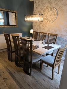comedor con mesa de madera y sillas en Spacious 4 Bed Victorian House with Sea Views, en Ilfracombe