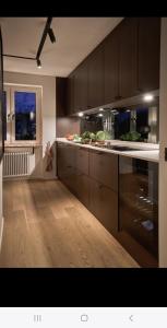a kitchen with brown cabinets and a wooden floor at 2 bedroom apartment close to Eurovision in Malmö